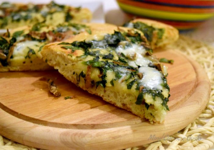 Pizza gustosa e croccante con spinaci e acciughe